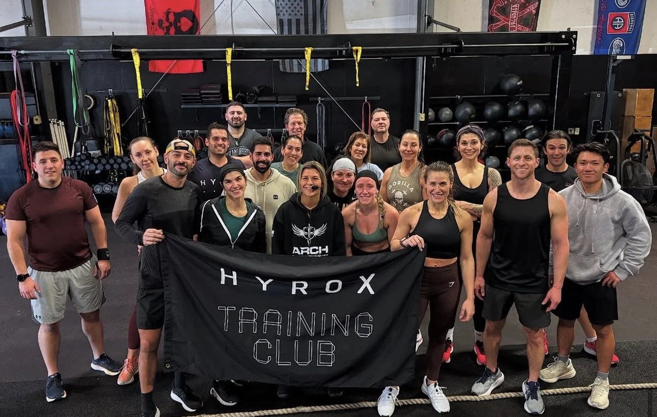 ARCH athletes together with their HYROX Training Club banner